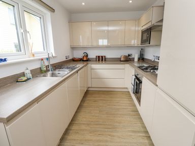 A kitchen with countertop appliances and cabinets at Turning Tide in Beadnell