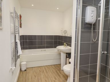 A bathroom with a bathtub sink toilet and shower at Turning Tide in Beadnell