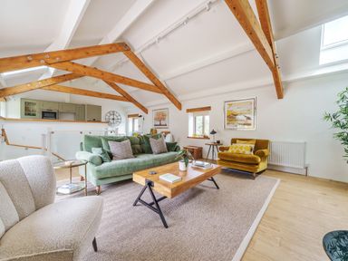 A living room with sofas wooden coffee table and exposed ceiling beams at The Granary in Davidstow near Camelford
