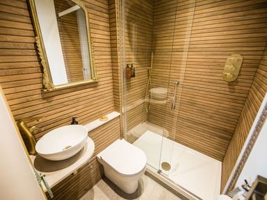 A bathroom with a toilet sink mirror and glass shower enclosure at Casa Formentera in Scarborough