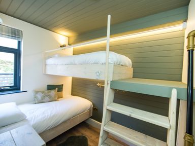 A bedroom with a wooden bunk bed ladder and a window at Casa Formentera in Scarborough