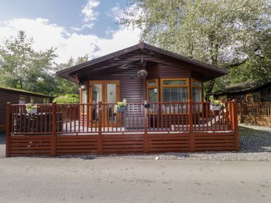 A house with a deck and planters at Ruskin Lodge, Langdale 16, White Cross Bay near Windermere