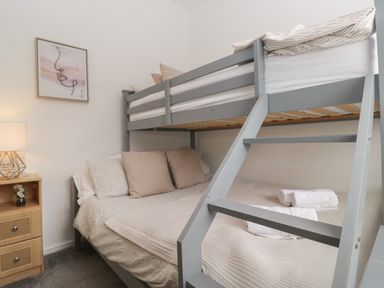 A bedroom with a bunk bed and double bed at Ruskin Lodge in Langdale 16, White Cross Bay near Windermere