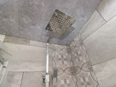 A shower with modern fixtures and patterned tiles at Ruskin Lodge Langdale 16, White Cross Bay near Windermere