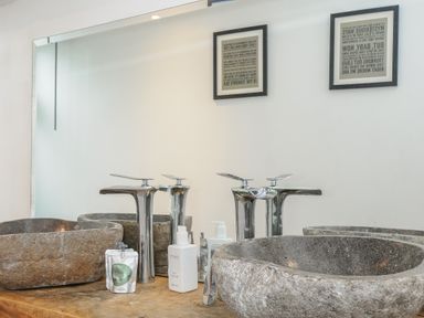 A bathroom sink area with two stone vessel sinks and modern chrome faucets at Moons Cottage in Fowey
