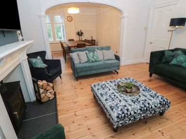 A living room with sofas armchairs coffee table and dining table with chairs at St Aidans in Alnwick