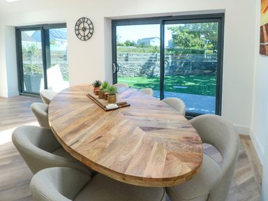 A dining room with a table and chairs at Iscoed in Rhosneigr