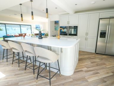 A kitchen with a large island and bar stools at Iscoed in Rhosneigr