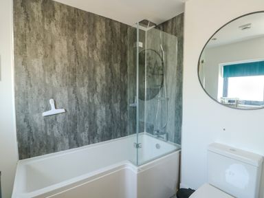 A bathroom featuring a bathtub and shower at Iscoed in Rhosneigr