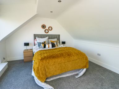 A bedroom with a bed and bedside table at Iscoed in Rhosneigr