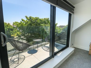 A balcony with chairs and a table at Iscoed Rhosneigr