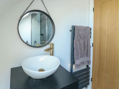 A bathroom with a sink and mirror at Iscoed Rhosneigr