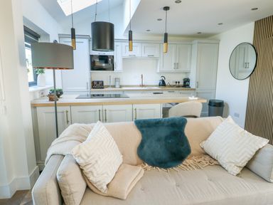 A living room with a kitchen countertop and sofa at Iscoed Rhosneigr