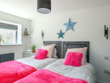 A bedroom with two beds and decorative stars at Iscoed in Rhosneigr