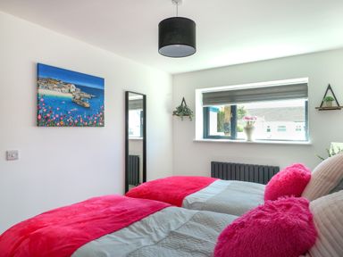 A bedroom with two beds and a window at Iscoed Rhosneigr