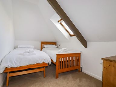 A bedroom with two single beds and a skylight window at Penang in St Austell