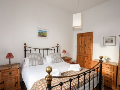 A bedroom with a double bed and wooden furniture at East Point Lynas Lighthouse Keeper's Cottage in Llaneilian near Amlwch