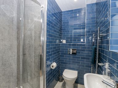 A bathroom with a shower, toilet, and sink at Ranbir House in Longhope