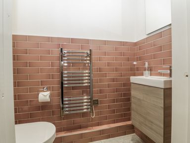 A bathroom with a toilet, sink, and towel radiator at Ranbir House in Longhope
