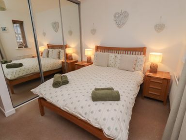A bedroom with a double bed and bedside tables at Brucap Cottage Beadnell