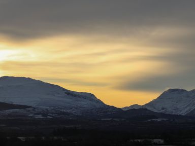 A snowy mountain landscape under a cloudy yellow sky at Iscoed in Llangefni