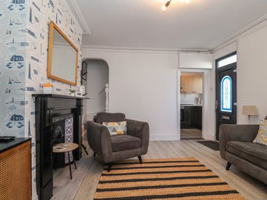 A living room with two armchairs a striped rug and a black fireplace at 11a Manning Road Felixstowe Suffolk