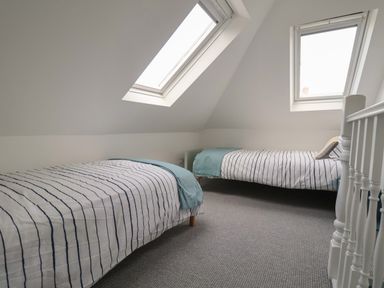 A bedroom with two single beds under skylight windows at 11a Manning Road in Felixstowe Suffolk