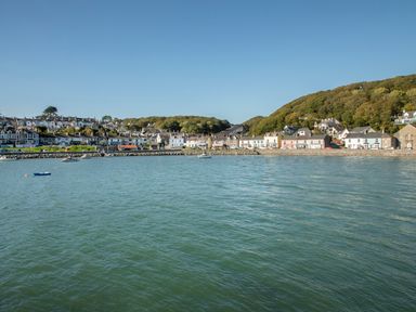 A coastal village with houses along the shore and boats on the water at Bwthyn in Borth-y-Gest near Porthmadog