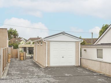A driveway with a detached garage and a fenced side path at Rhiwlas Bach in Benllech