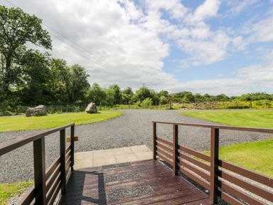 A view of a gravel driveway with grass lawns and trees in the background at Glenisle in Dalbeattie