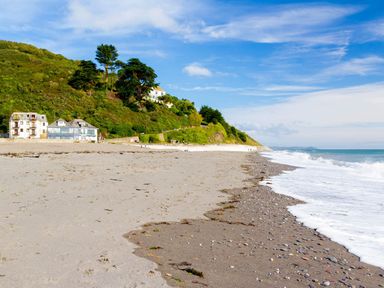 A beach with houses and a hill at 4 Valley View in Lanreath