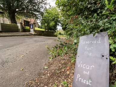 A churchyard road with a sign reserved for the vicar and priest at The Happy Hut in Sopley near Christchurch