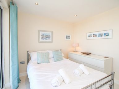 A bedroom with a double bed and rolled towels at Sunset View in Castletown Portland