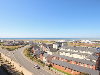 A coastal town with residential buildings roads and industrial structures near the sea at Sunset View in Castletown Portland