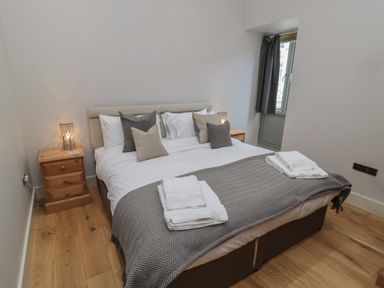 A bedroom with a double bed pillows bedside tables and lamps at The Coach House in Bamburgh