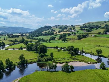 A landscape with a river and fields at Hay Store in Corwen
