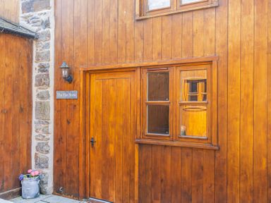 An exterior view of The Hay Store with a wooden door and window in Corwen