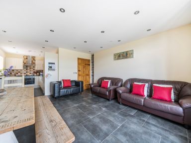 A living room with sofas and a kitchen area at Hay Store in Corwen