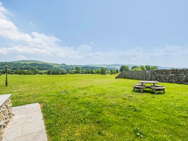 A field with a picnic table and a lamp post at Hay Store in Corwen