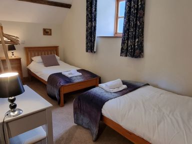 A bedroom with two beds and a dresser at Hay Store in Corwen