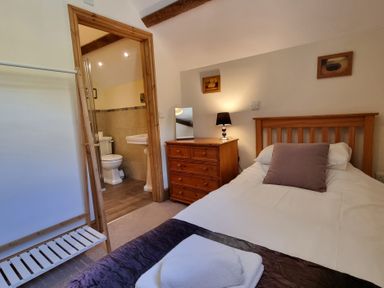 A bedroom with a bed and attached bathroom at Hay Store in Corwen