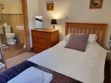 A bedroom with a bed and bathroom area at Hay Store in Corwen