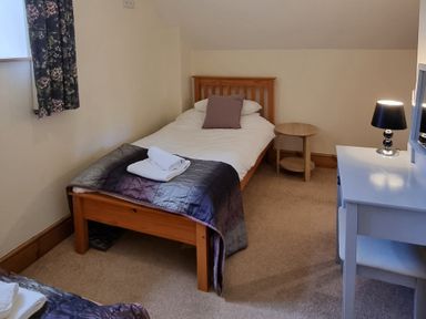 A bedroom with a single bed and a desk at Hay Store in Corwen