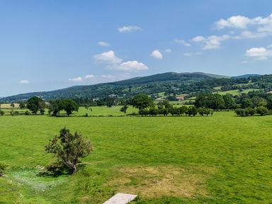 A view of green fields and hills at The Barn in Corwen