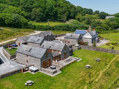 A view of multiple buildings and green space at The Barn in Corwen