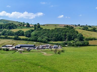 An aerial view of a farm with buildings and fields at The Barn in Corwen