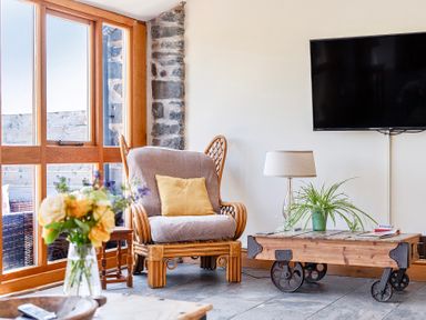 A living room with an armchair and a coffee table at The Barn in Corwen