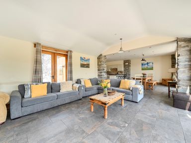 A living room with a sofa and table at The Barn in Corwen