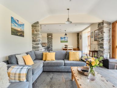 A living room with a sofa and coffee table at The Barn in Corwen