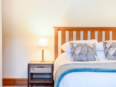 A bedroom with a bed and nightstand at The Barn in Corwen